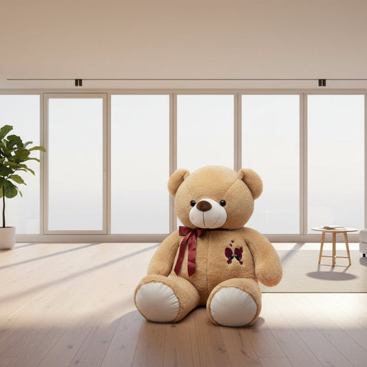 Brown teddy bear with a red bow and embroidered design on a white background