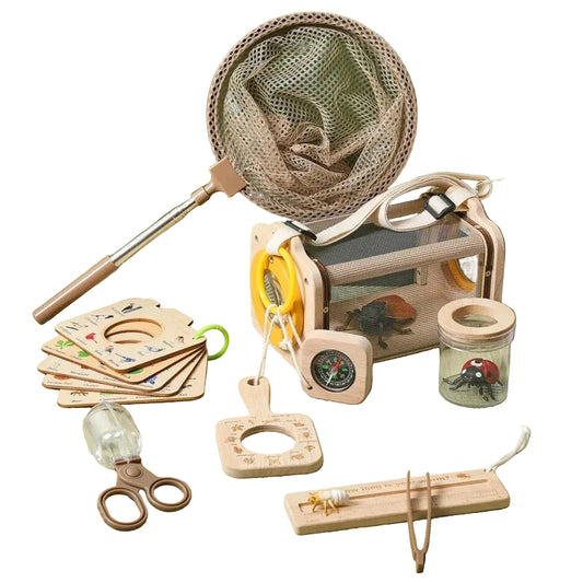 Children's nature exploration kit with a net,放大镜,放大镜, scissors, and cards on a green surface.