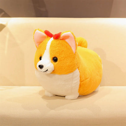 A cute, round plush toy dog with a yellow and white body, pink inner ears, and a small red bow on its head, sitting on a beige surface.