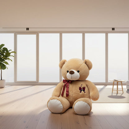Brown teddy bear with a red bow and embroidered design on a white background