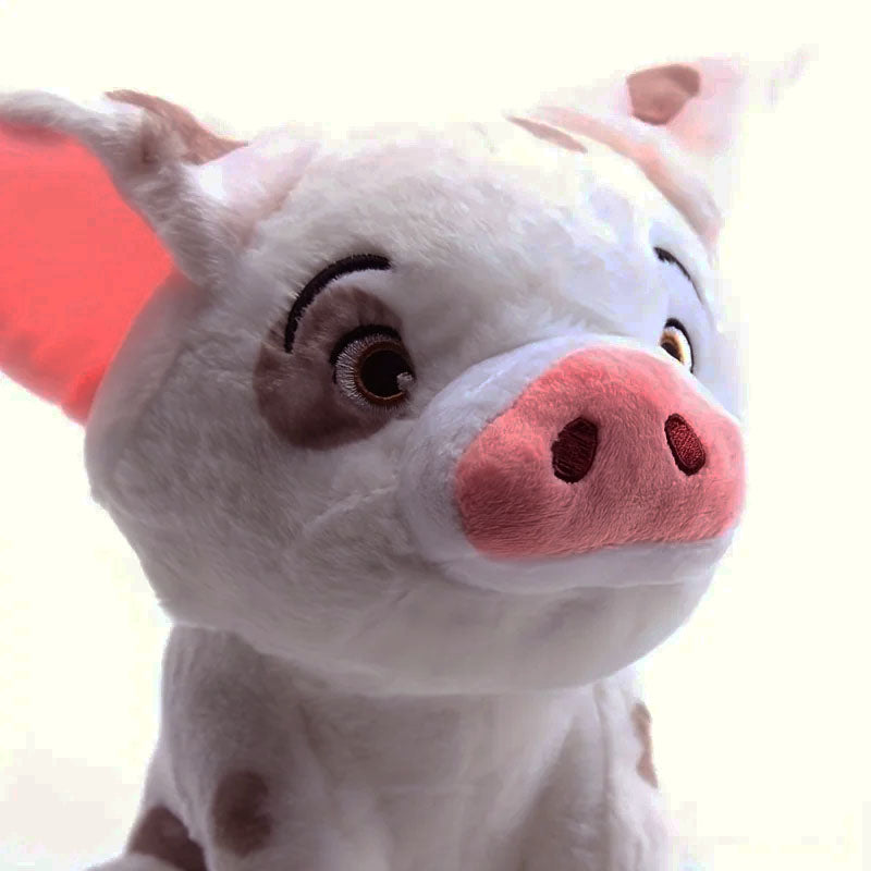 A close-up of a plush toy pig with white fur, pink snout and ears, and brown patches, photographed against a bright white background.