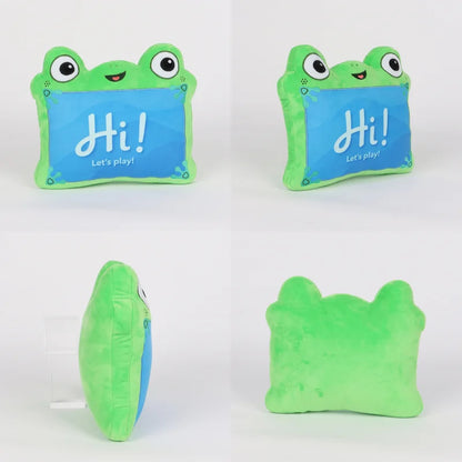A plush frog-shaped pillow shown from multiple angles on a white background. The front view shows a bright green frog outline with large cartoon eyes and a blue center panel that reads “Hi! Let’s play!”.
