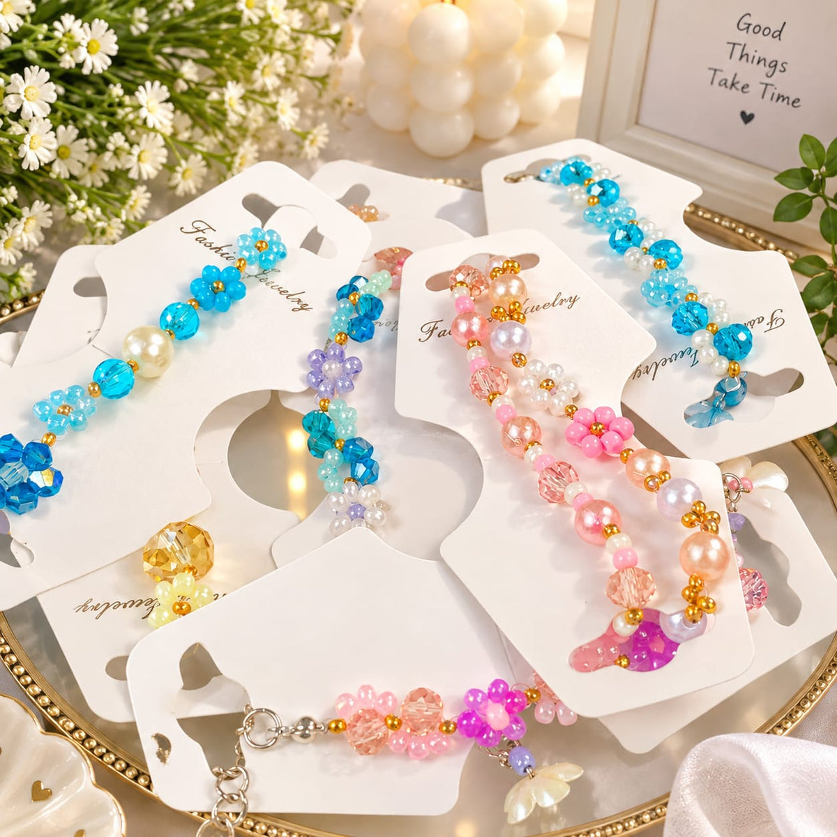 Several beaded Bracelets For Women displayed on white card holders on a decorative tray. The clips feature colorful beads in blue, pink, purple, and pearl white, with floral bead motifs and small gold-tone accents.