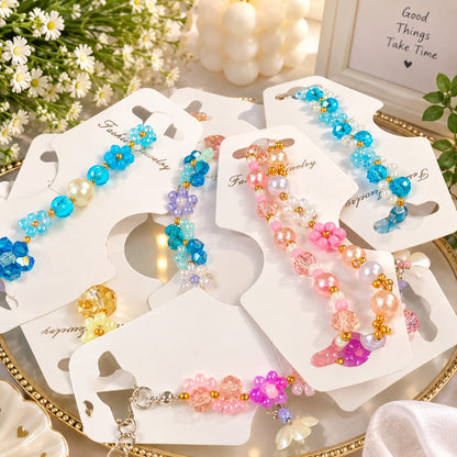 Several beaded Bracelets For Women displayed on white card holders on a decorative tray. The clips feature colorful beads in blue, pink, purple, and pearl white, with floral bead motifs and small gold-tone accents.
