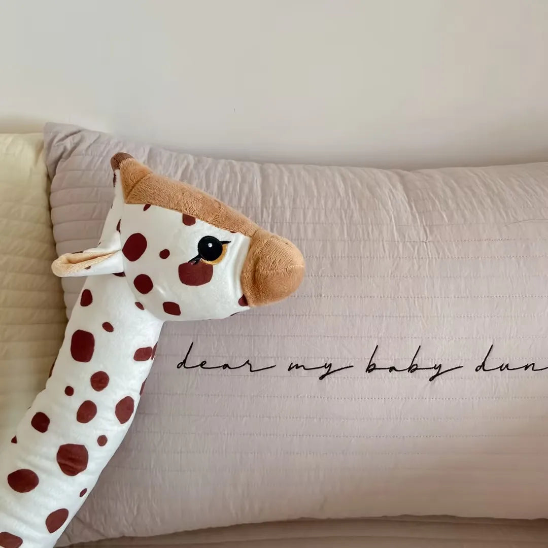 Giraffe plush toy on a pillow with 'dear my baby hun' text