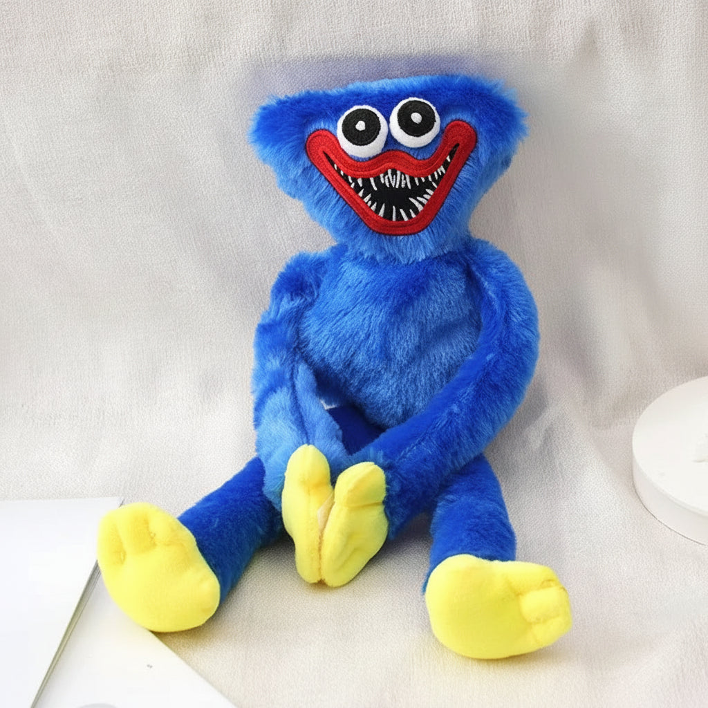 A blue furry plush toy resembling a cartoon monster with large white eyes, a wide red mouth, and yellow feet, posed against a light fabric backdrop.