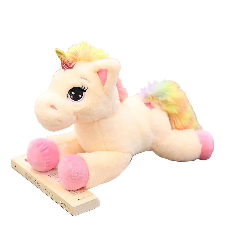 Plush unicorn toy on a wooden floor with books and a plant in the background